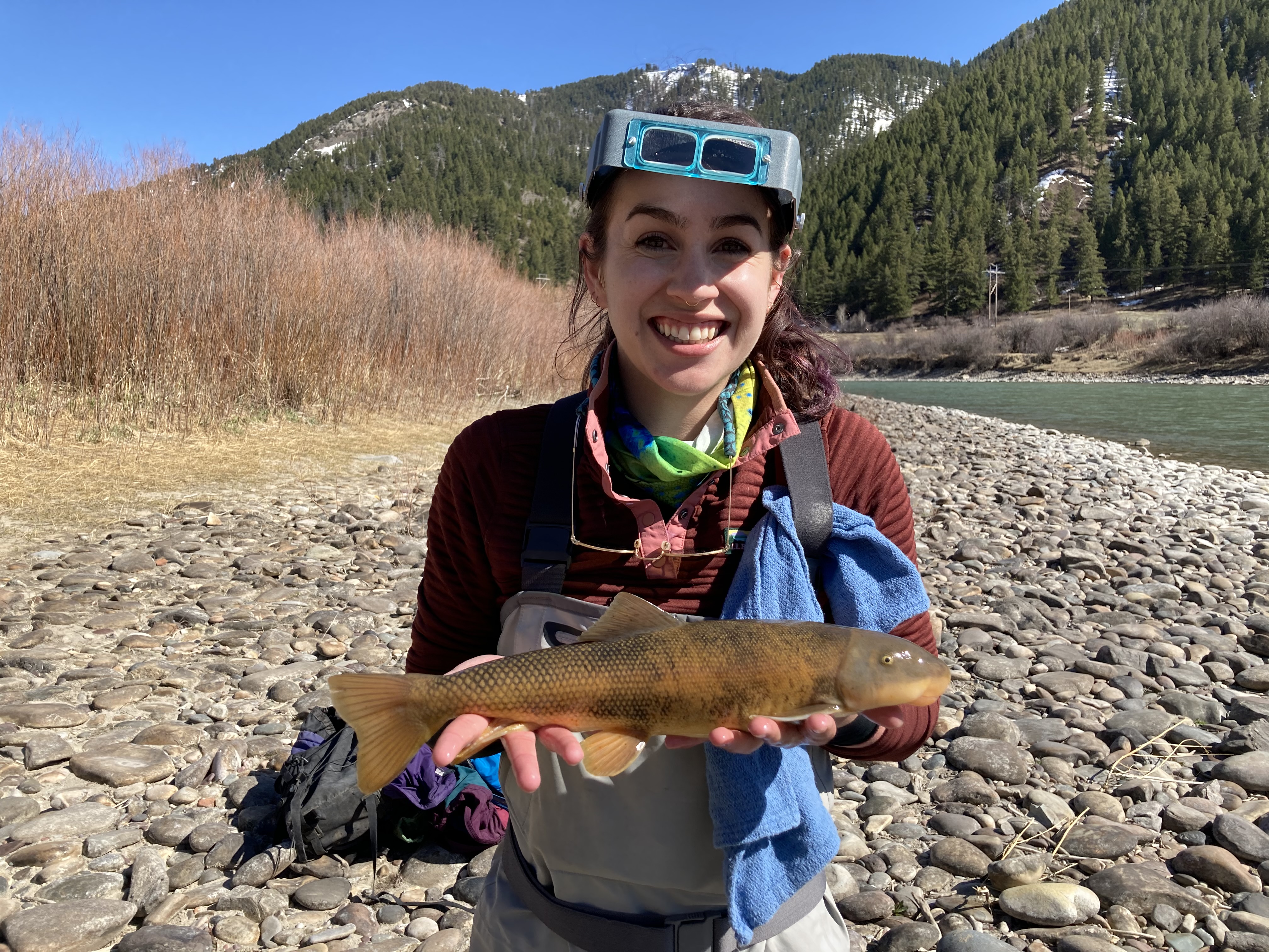 Brandy Smith poses for a photo holding a green sucker near the Snake River.