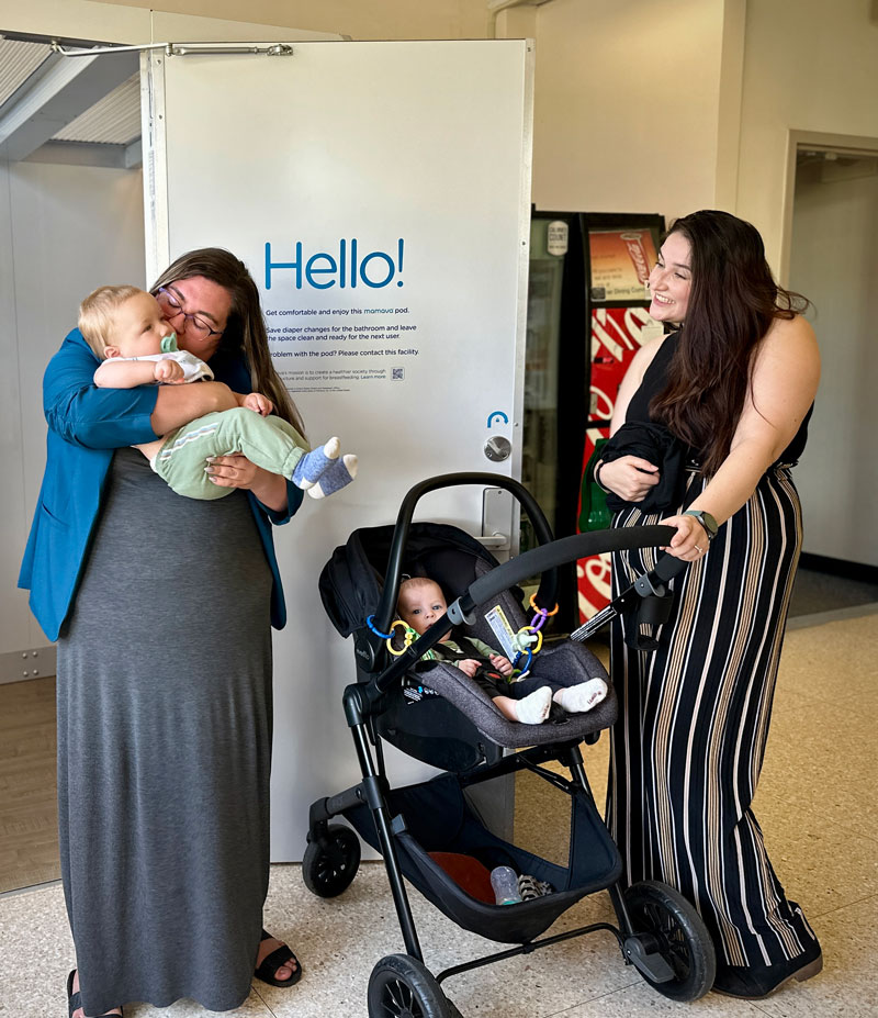 Two mothers with their babies near a Lactation Pod
